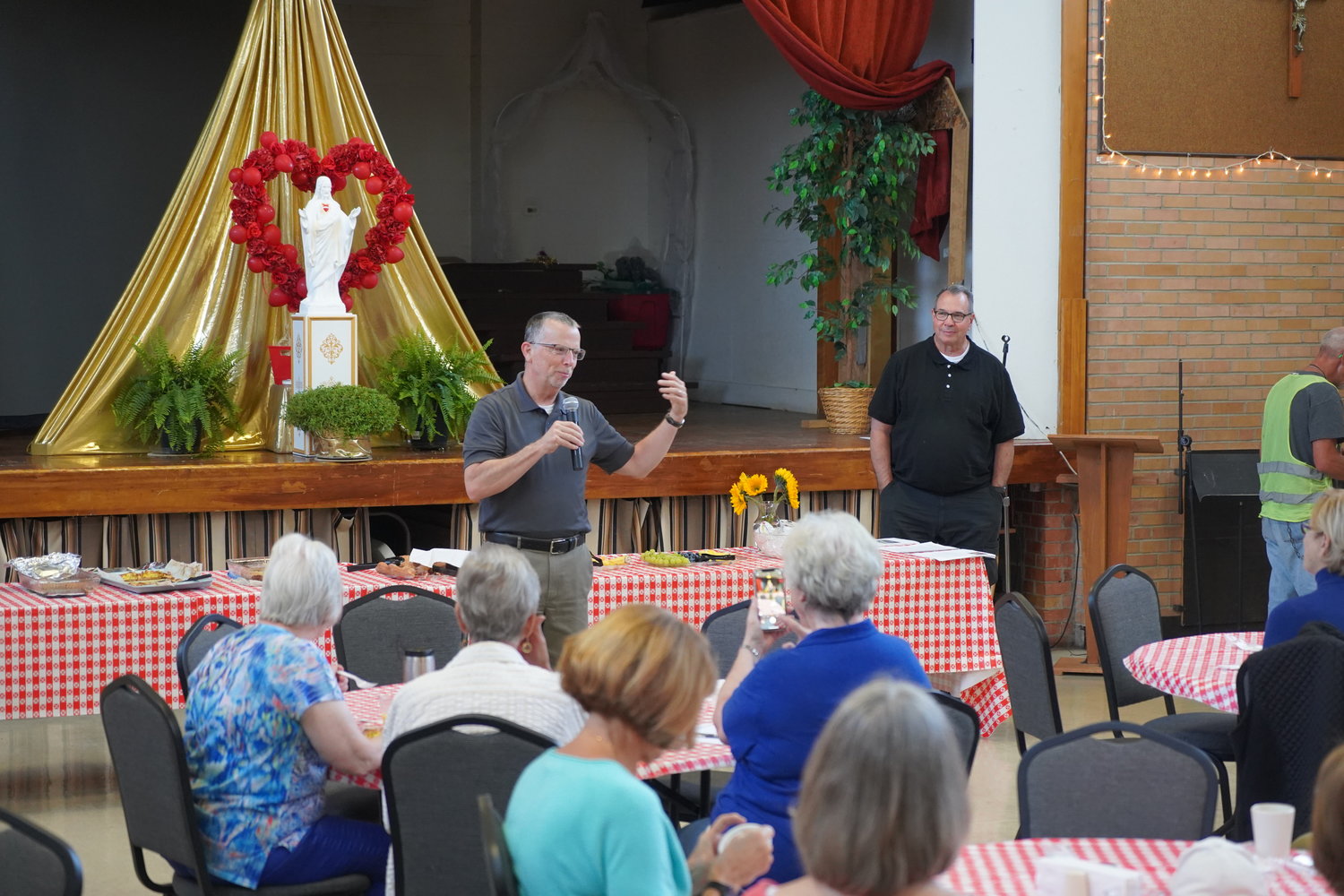 Tom Turner, former executive director and administrator of the Bishop Sullivan Center in Kansas City, leads the discussion, while Monsignor Gregory L. Higley, pastor, looks on.